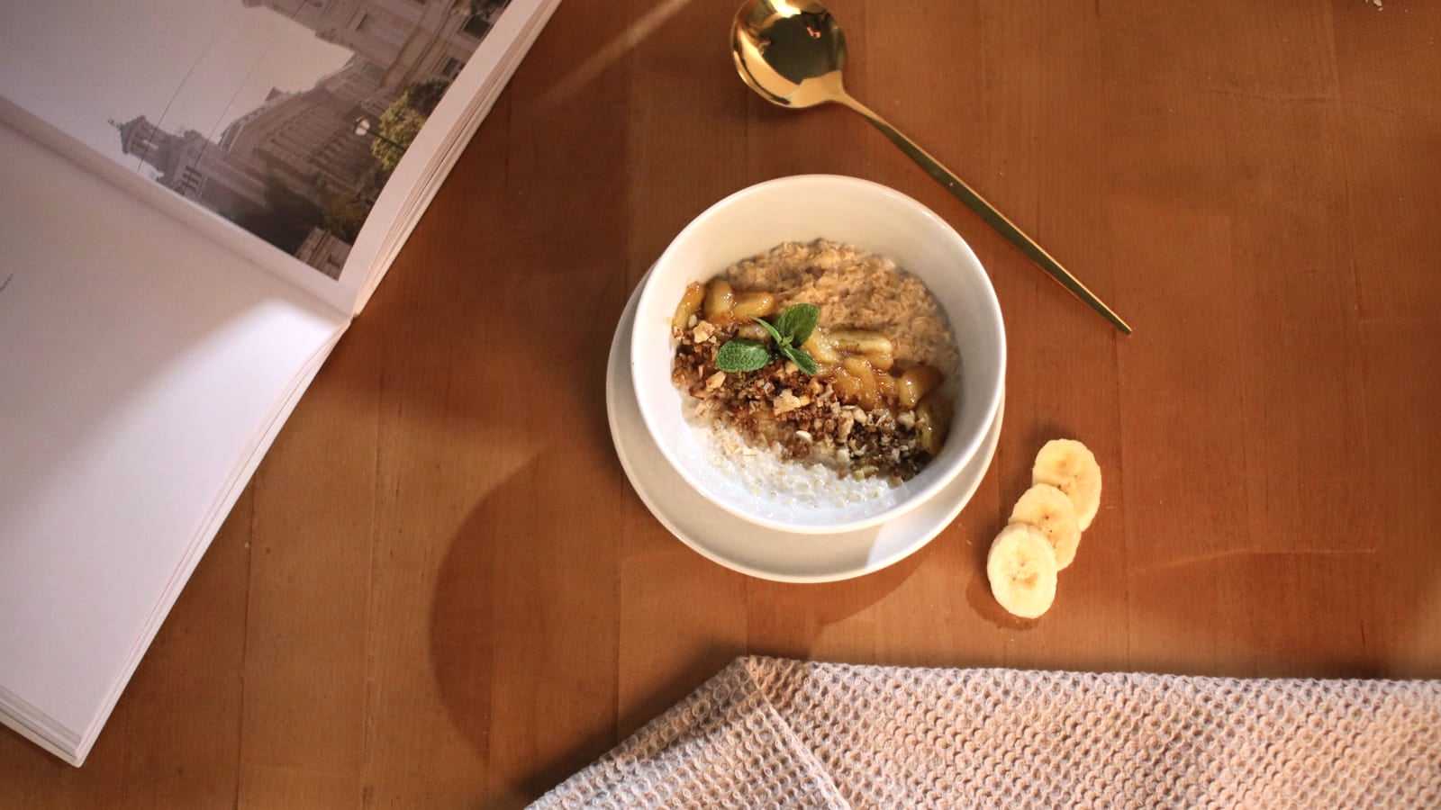 Una ciotola di porridge d'avena con fettine di banana su un tavolo di legno